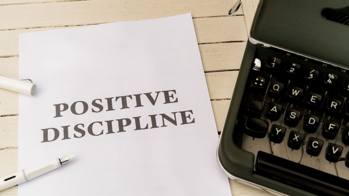 a piece of paper that says positive discipline next to a typewriter